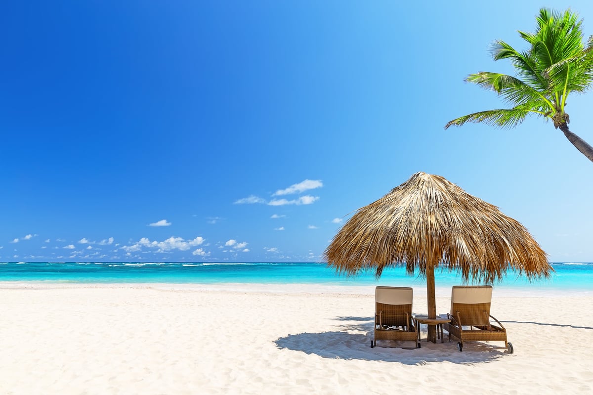Dos tumbonas vacías en un día soleado de verano en la playa